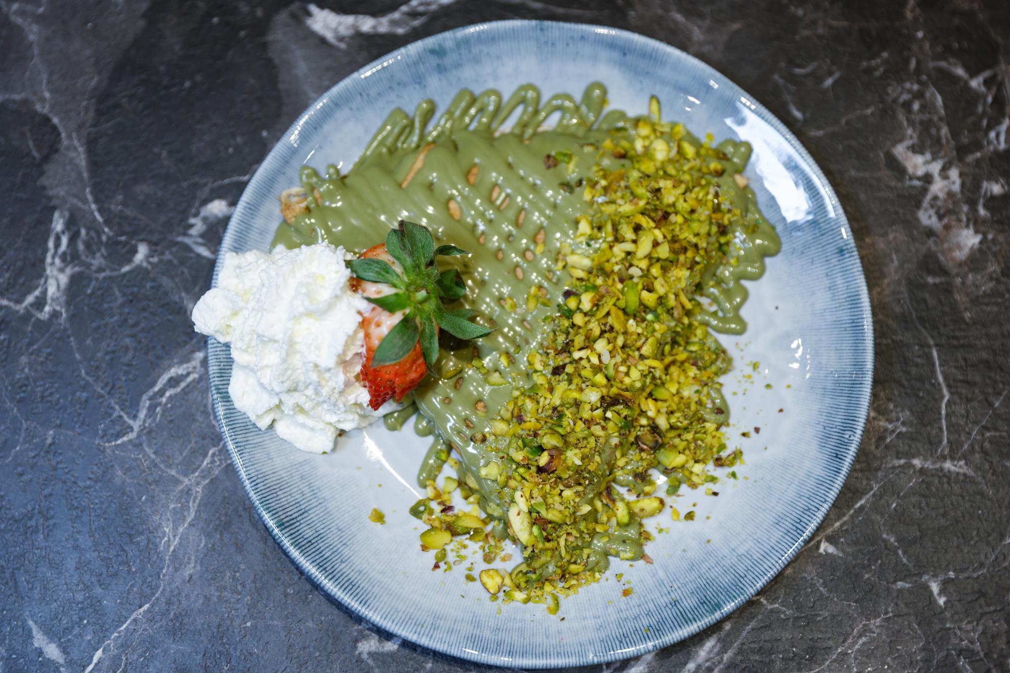 Vaffel med pistacie, flødeskum og jordbær set ovenfra