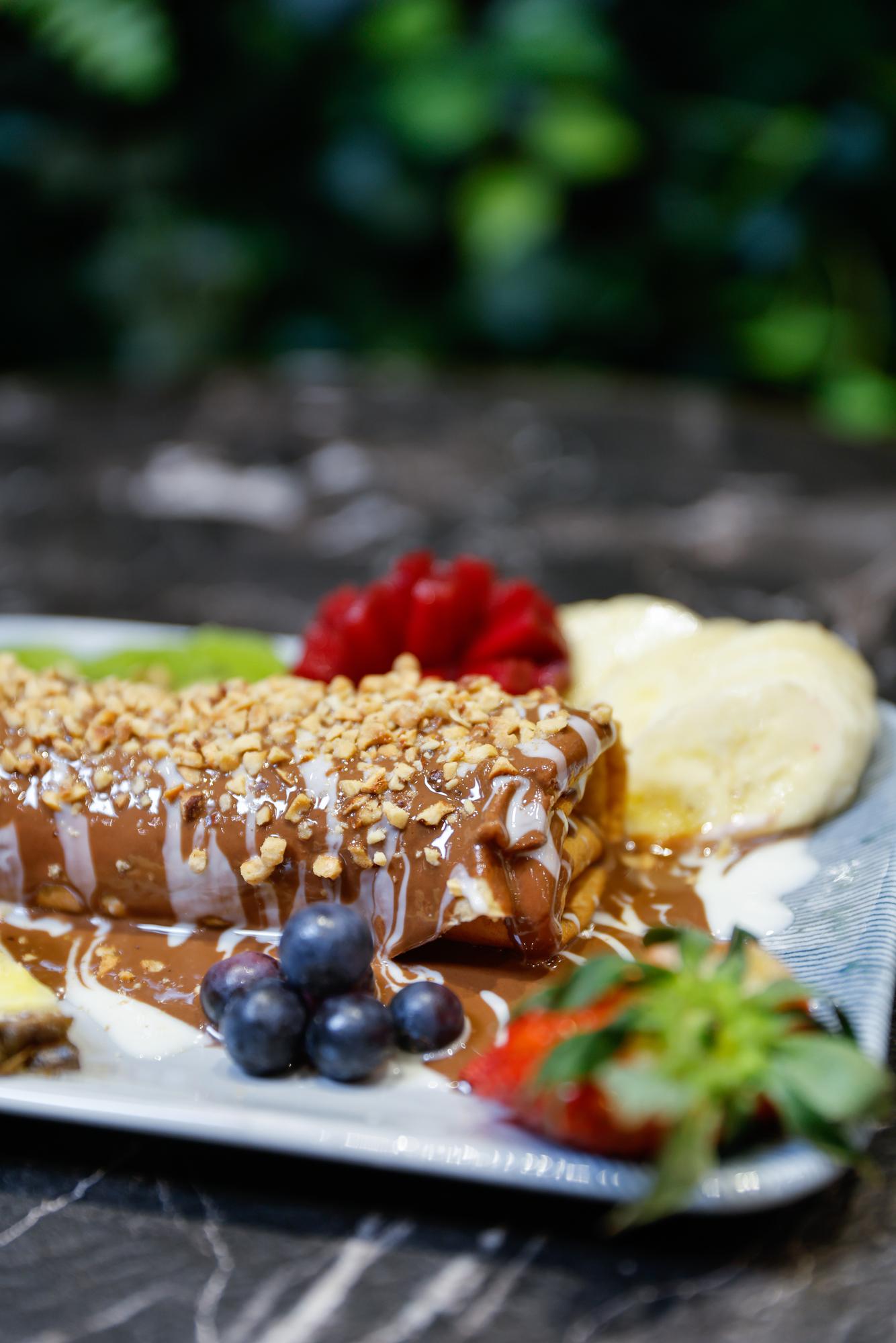 Dessert med karamelsauce, nødder og bær på tallerken udendørs