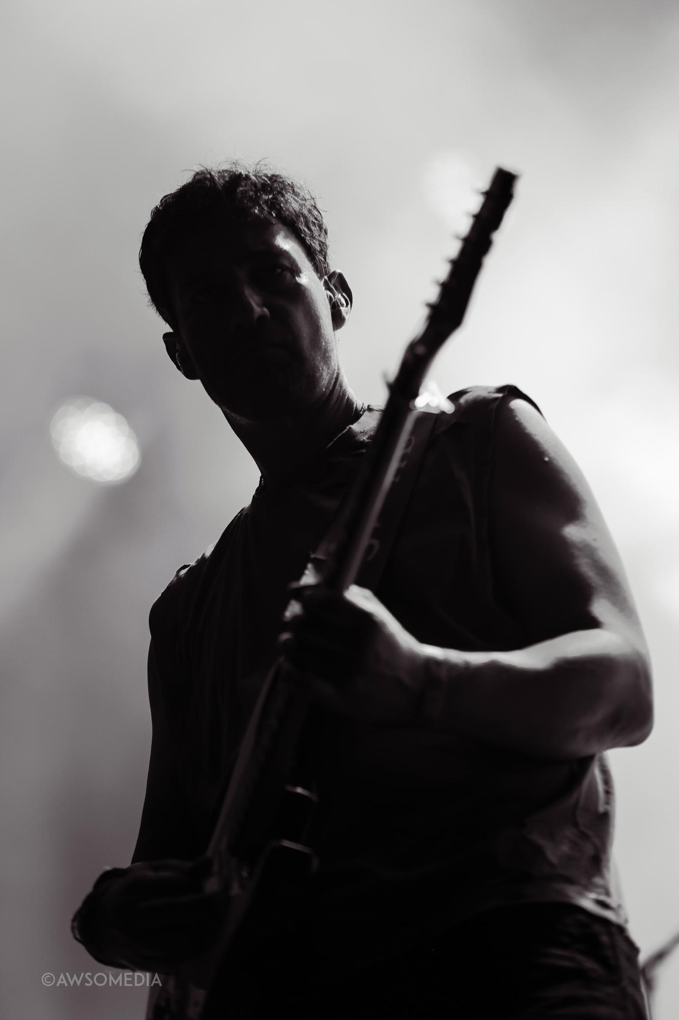Silhuet af guitarist på scenen i sort-hvid modlys