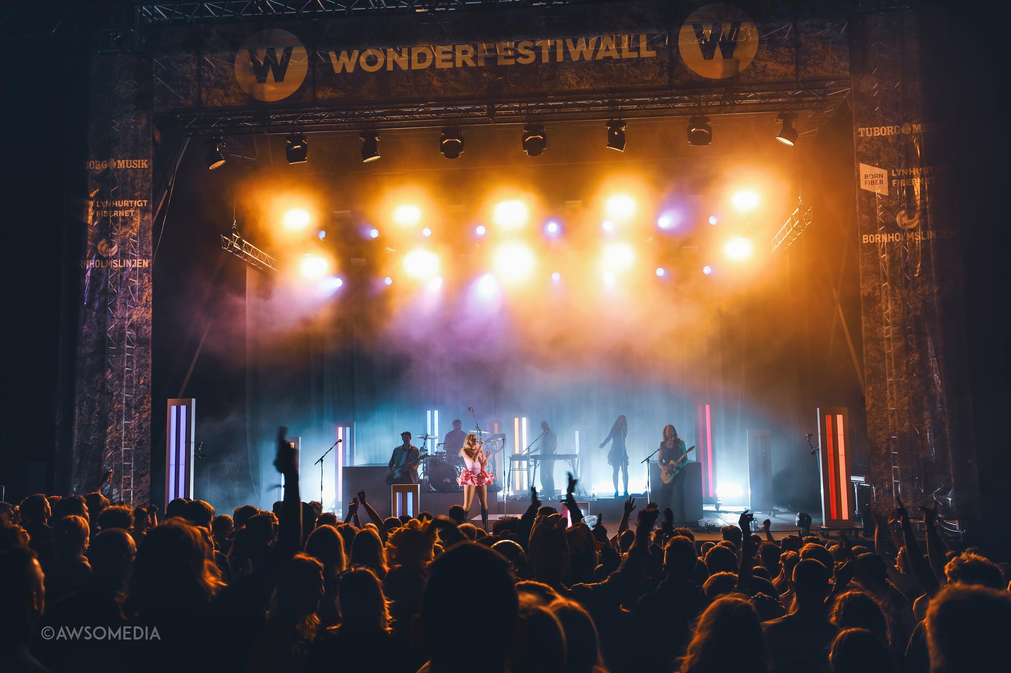 Festivalpublikum foran stor scene med bandet Wonderfestiwall