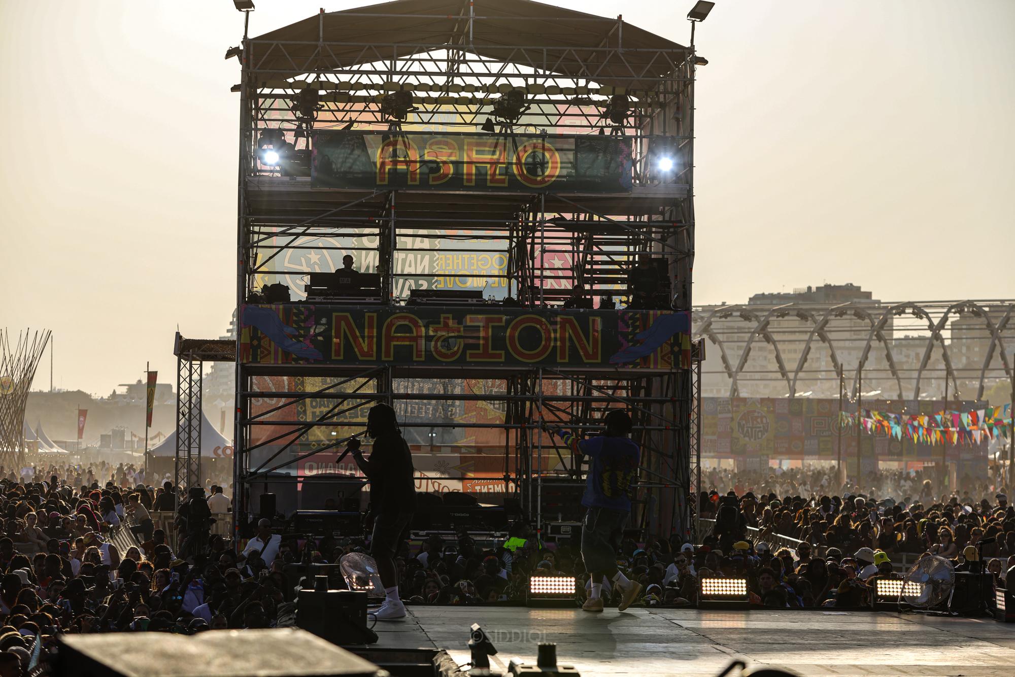 Festivalscene set fra oven med publikum og bygninger i baggrunden