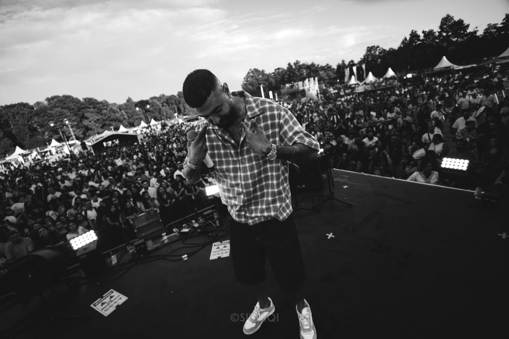 Sanger bukker sig frem foran et enormt dagslys-festivalpublikum
